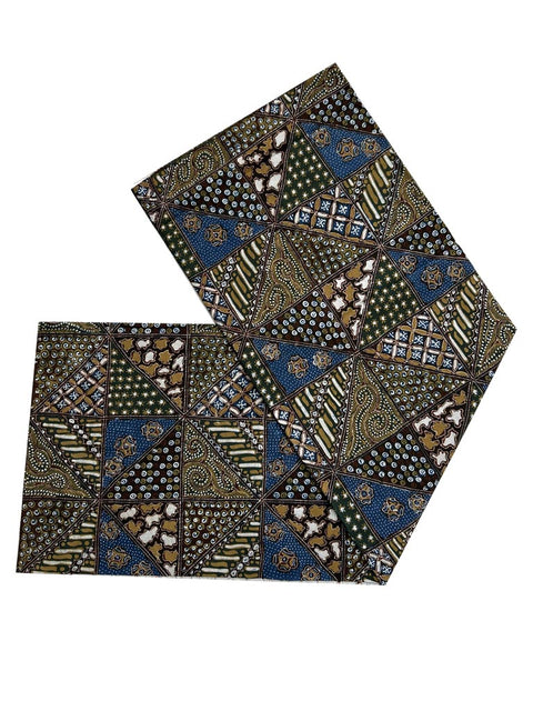Natural dyed batik fabric with a patchwork design, featuring shades of blue, green, and brown. The fabric has a textured appearance, with a mix of lighter and darker tones creating a dynamic pattern.