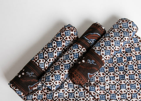 rolls of fabric showing batik in geometric patterns showing natural colors