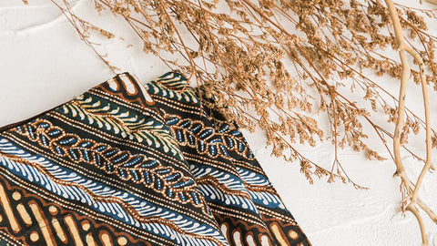 intricate batik fabric in display with dried flowers